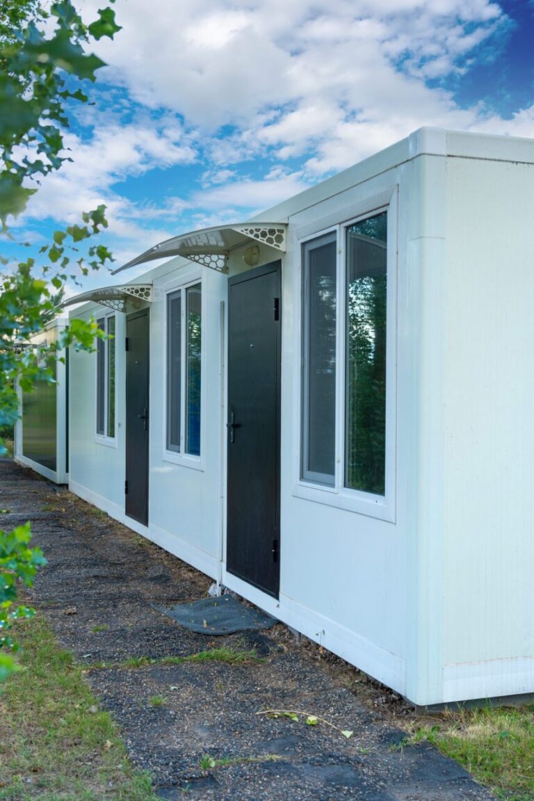Mobil-home moderne installé sur un terrain résidentiel arboré.