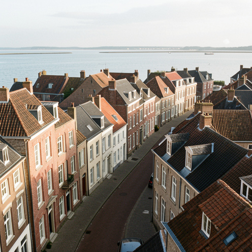 Vue panoramique de Saint-Valery-sur-Somme avec ses maisons anciennes, ses toits en tuiles et la baie de Somme en arrière-plan.